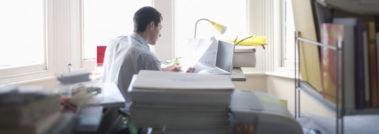 Businessman works from desk in bay window